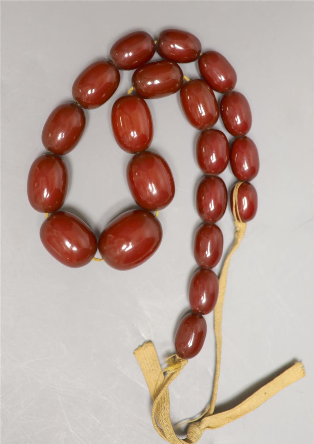 A single strand graduated simulated cherry amber necklace, 43cm, gross 75 grams.